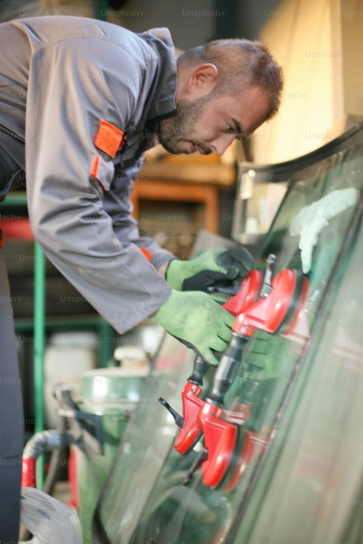Mechaniker beim Austausch einer Autoscheibe in der Werkstatt – GLASPOINT Linden